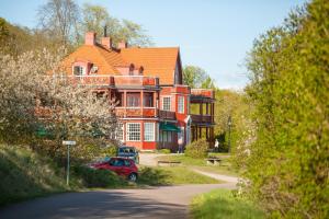 ÖdeshögOmbergs Turisthotell的一座大房子,前面有一辆红色的汽车
