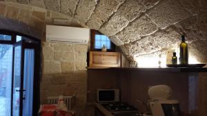 滨海波利尼亚诺库热迪彼得拉住宿加早餐旅馆的厨房设有石墙、炉灶和窗户。