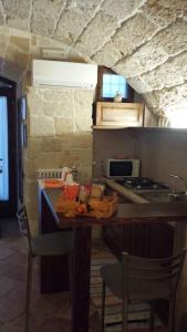 滨海波利尼亚诺库热迪彼得拉住宿加早餐旅馆的厨房配有桌椅和炉灶。