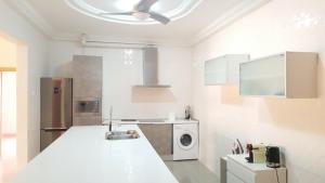 HohoeMuntala's Guest House的白色的厨房配有水槽和洗碗机