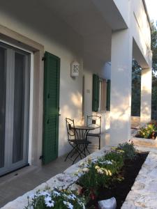 科拉托Villa Valeria B&B的一个带桌椅的庭院和一扇绿门