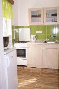 埃格尔Like Apartman的厨房配有白色炉灶和水槽