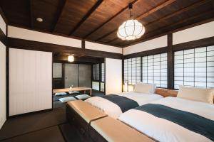 日南Kiraku Obi的带窗户和桌子的客房内的两张床