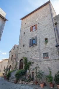 维泰博Antica Dimora San Pellegrino的一座带窗户和盆栽植物的大型石头建筑