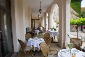 古克斯哈根Hotel Bellini的一间带白色桌椅的餐厅和一个庭院