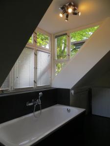柏林Fischerhaus am See的带窗户的浴室内的白色大浴缸