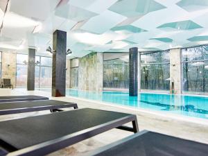 科沃布热格VacationClub - Diune Apartment 41的一座带桌子和窗户的游泳池