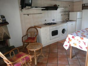 卡梅罗塔码头Villino Iolanda的厨房配有炉灶和桌椅