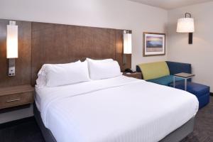 布赖恩特Holiday Inn Express and Suites Bryant - Benton Area, an IHG Hotel的酒店客房带一张大床和一把椅子