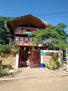 曼克拉Wiracocha Hostal Máncora - Surf Camp的茅草屋顶的小房子