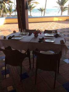 卡约港Casa Amarilla的一张桌子、两把椅子和一张桌子及酒杯
