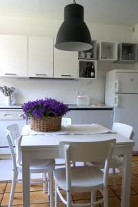 加尔达湖滨Casa Smile的厨房配有白色桌子和紫色花篮