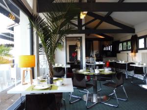 阿维尼翁新城O'Cub Hotel的一间配备有桌椅的用餐室和植物