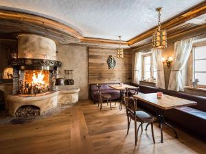 佩尔蒂绍Hotel Alpenrose的一间带壁炉和桌椅的餐厅