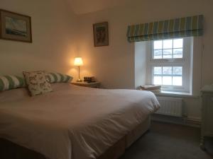 克里克豪厄尔The Kestrel B&B的卧室配有白色的床和2扇窗户。