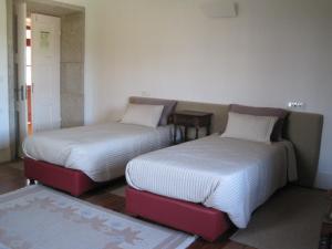 SobrosaCasa da Torre的两张睡床彼此相邻,位于一个房间里