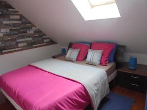滨海克里耶勒西格尼斯度假屋的一间卧室配有带粉红色和蓝色枕头的床