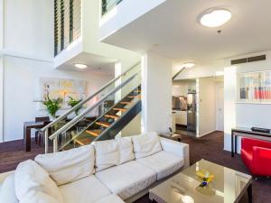 布里斯班Felix 374 FF Apartment的客厅设有白色沙发和楼梯。