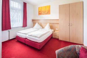 诺德奈巴科尔酒店的一间卧室配有两张床,铺有红地毯