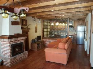 NavalguijoCasa Rural El Castaño的带沙发和壁炉的客厅