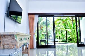 努沙杜瓦巴厘岛棕榈园酒店的客厅设有壁炉和电视。