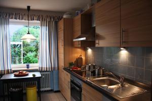 奥特尔恩多夫Villa Ludwig Fewo的厨房配有木制橱柜、水槽和窗户。
