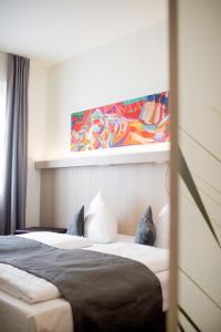 克洛彭堡Hotel Cloppenburg的一间卧室设有两张床,墙上挂着一幅画