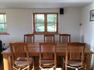 奥斯威斯Maesbury Riverside的一间带木桌和椅子的用餐室