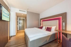 哈恩Best Western Plus Hotel Stadtquartier Haan的酒店客房设有一张大床和一张桌子。