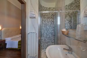 都灵阿尼维守酒店的浴室配有水槽和带浴缸的淋浴
