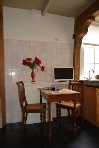 蒙尼肯丹Waterland Achterhuis的厨房配有桌子和两把椅子以及电视。