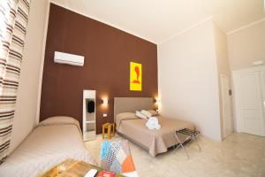那不勒斯PC Boutique H Napoli Centro, by ClaPa Group的一间卧室设有两张床和棕色的墙壁
