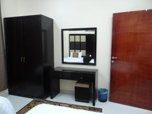 代瓦西尔干河Royal Home Furnished Apartments的一间卧室配有黑色梳妆台和镜子