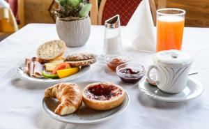 因斯布鲁克巴嫩韦尔特酒店的一张桌子,上面放着两盘早餐食品和饮料