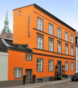 施特拉尔松德Pension Altstadt Mönch in top Lage Preis inclusive 5 Prozent Bettensteuer und Frühstück的一座橙色的建筑,上面有标志