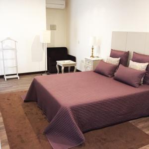 吉尔斯Hotel Central Jardim的一间卧室配有一张带紫色床单的大床