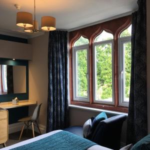 温德米尔温德米尔隐居旅馆（仅限成人）的酒店客房设有一张床和两个窗户。