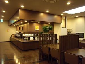 鹤冈市鹤冈站前路线酒店的一间带柜台和桌椅的餐厅