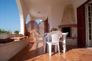玛丽娜迪曼卡维萨Ville Mancaversa的庭院配有桌椅和壁炉。
