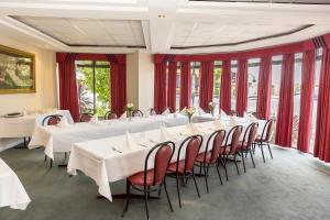 巴拉腊特巴克利汽车旅馆的一间会议室,配有白色的桌子和红色的窗帘