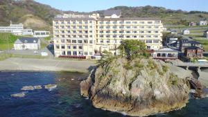 鹤冈市尤拉温泉八乙女日式旅馆 的一座大建筑前水面上的岛屿