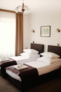克拉科夫艾登酒店的一间设有三张床的客房,备有毛巾