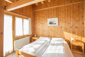 弗利姆斯拜格豪斯纳根斯旅舍的卧室配有木墙内的一张床
