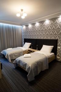 波兹南Szczęśliwa 13的一间卧室设有两张床和一堵墙