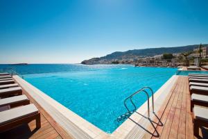 卡尔帕索斯阿丽蒙德马蕾酒店的一个带椅子和水的大型游泳池