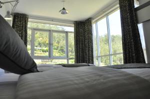 努沃勒埃利耶森林景观旅馆的一间卧室设有一张床和一个大窗户