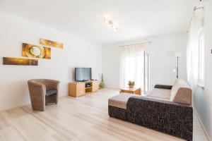 普拉纳塔利娅公寓的客厅配有床、沙发和电视。
