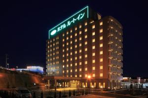 仙台森带祖米路特因特酒店的一座建筑物,上面有夜间标志