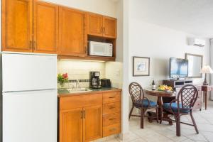 格雷斯湾皇家西印度群岛度假屋的厨房配有桌子和白色冰箱。