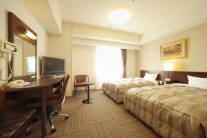 仙台仙台长町国际茹特酒店的酒店客房配有两张床和一张书桌